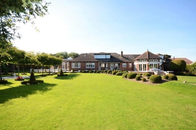 It features well-manicured gardens to the front and rear, boasting both countryside and coastal views.