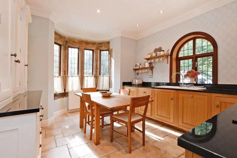 The kitchen diner is a lovely room with Farrow and Ball decorative tones, a beautiful front bay window, and a side arched window, says the brochure.