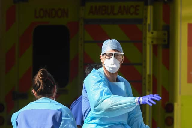 Doctors wearing protective equipment are seen loading a patient in to an ambulance (Photo by Peter Summers/Getty Images)