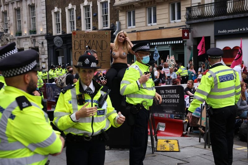 A climate protestor bares all as police look on in Covent Garden (Photo by Dan Kitwood/Getty Images)