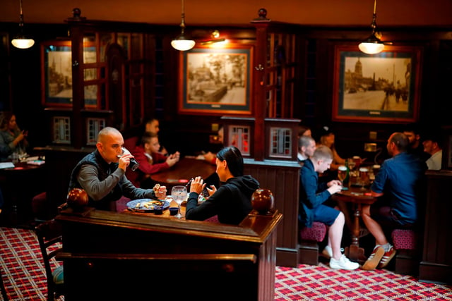 Seated customers eat and drink inside the Wetherspoon pub, as restrictions are further eased during the novel coronavirus COVID-19 pandemic. (Photo by Tolga Akmen / AFP) (Photo by TOLGA AKMEN/AFP via Getty Images)