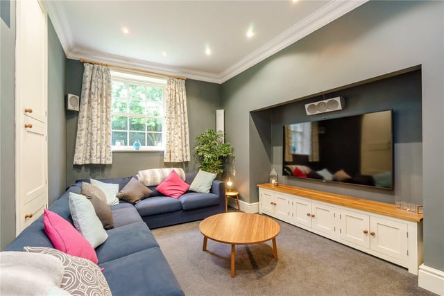 This snug cinema room is perfect for relaxing with family and friends, and boasts a wall mounted TV, built-in cupboard and a feature alcove.