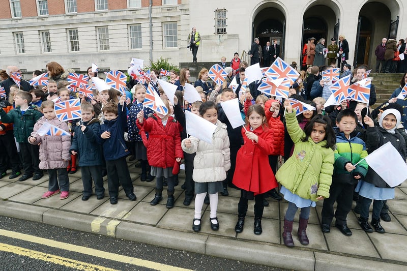 Children from Highfield Hall primary school wave the flag as The Mercians march in Chesterfield.
