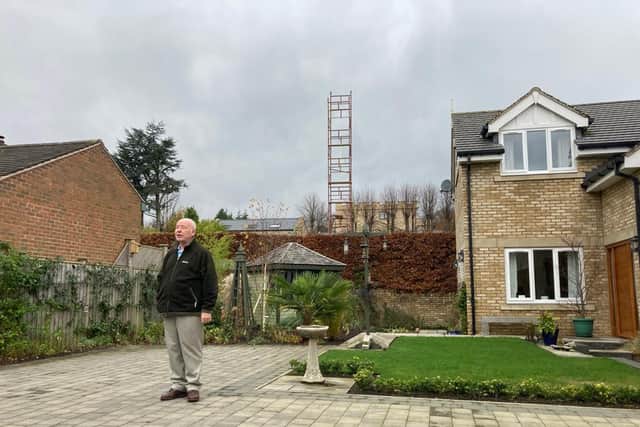 Alan Disney on the patio of his home in Dore, with the scaffolding tower behind
