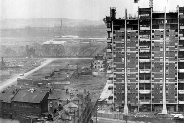 1960:  Modern housing under construction beside old tenements.