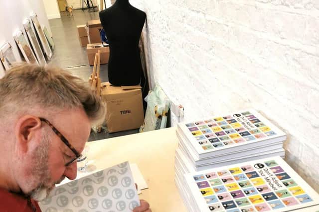 Pete McKee signs the guide to his latest exhibition Don't Adjust Your Mindset