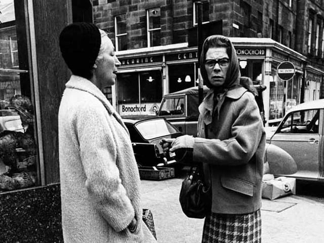 Two women talking with one another on William Street in Edinburgh.