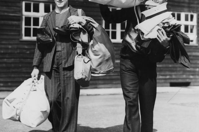 10th April 1951:  Sydney Woods (left) and W M Bell, the first of the naval reservists rercently called-up, arriving with their kit at their depot in Portsmouth.  (Photo by Ron Burton/Keystone/Getty Images)