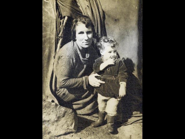 Woman and boy at the entrance to their bow tent.