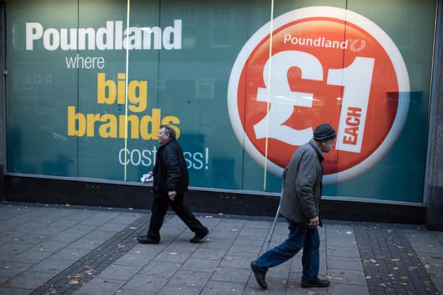 Members of the public make their way past a Poundland discount store (OLI SCARFF/AFP via Getty Images)