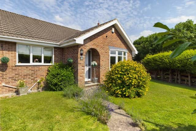 Front elevation - Partially enclosed with boundary hedge, laid to lawn with a variety of mature plants and shrubs, paved path and driveway, double timber gates providing secure access to the rear garden and garage. Further single timber access gate opening into the rear garden.