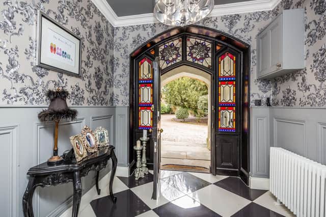 An impressive entrance hall with original glazed door, ornate panelling to the walls and tiled flooring with underfloor heating.