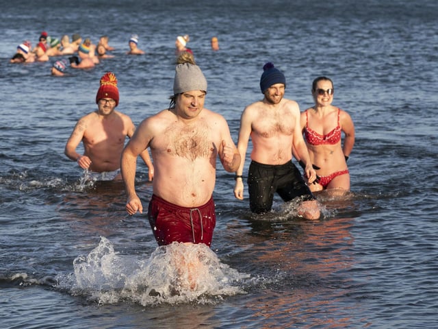 People swim and take a dip in the Firth of Forth at Portobello Beach in Edinburgh on New Year's Day. Picture date: Saturday January 1, 2022. PA Photo. Photo credit should read: Jane Barlow/PA Wire