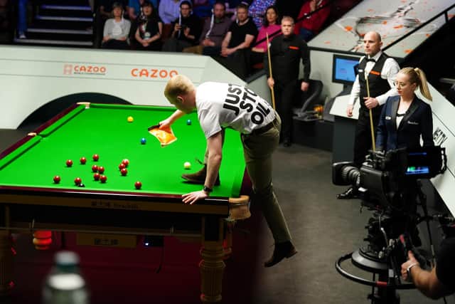 A protestor, Eddie Whittingham, from Just Stop Oil brought play to a halt at the World Snooker Championship on April 17 in Sheffield when they climbed onto the table and dumped out a bag of orange powder paint. Mike Egerton/PA Wire.