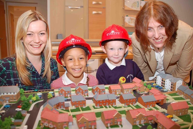 Talia Knight and Frankie Wigley, both 6, get a bird's eye view of the model of Barratt's The Spires development in Chesterfield with sales negotiator Caroline Hale and teacher Jane Garrett in 2006