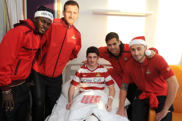 Theo Robinson, Chris Brown, Harry Forrester and Billy Paynter give a present to Rovers fan Sam Bailey, 13, of Skellow at DRI during Christmas 2013