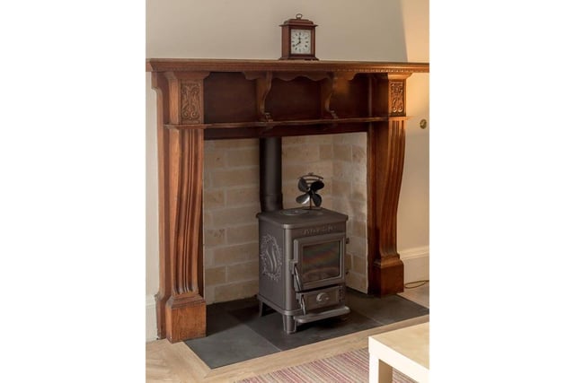 The drawing room features a wood burning stove with timber mantelpiece.