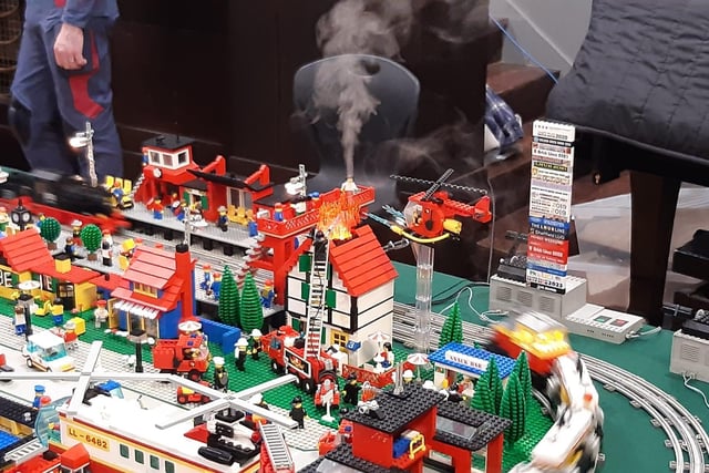 One display, which was being circled by powered Lego trains. had an active emergency scene, with fire services working outside this house.