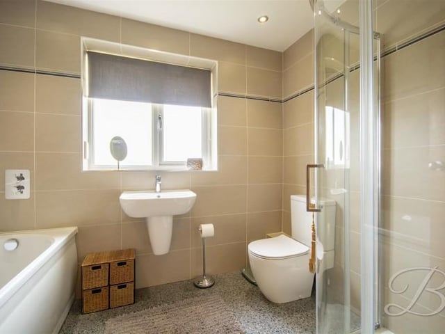 A "delightfully" well appointed family bathroom, fitted with a suite in white comprising; panelled bath, shower cubicle, low level WC and a wall mounted wash hand basin.