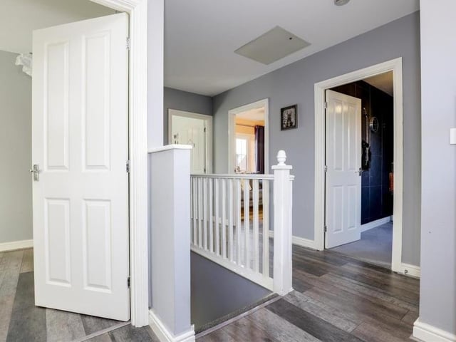 The staircase in the hallway guides you to this first-floor landing. It has laminate flooring, a wall-mounted radiator, a a built-in cupboard, a uPVC double-glazed window to the back of the house and also access to a boarded loft with lighting.