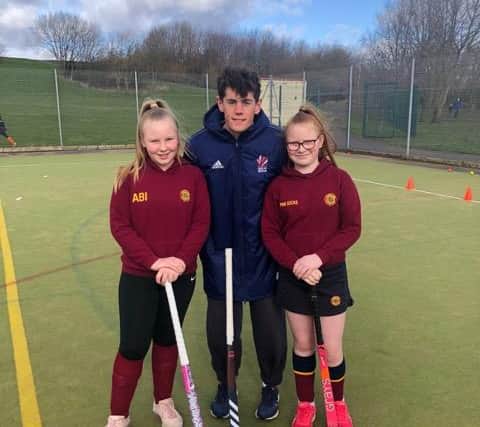 English international field hockey player, Tom Sorsby, who plays as a midfielder for the England and Great Britain pictured with junior members of Chapeltown Hockey Club