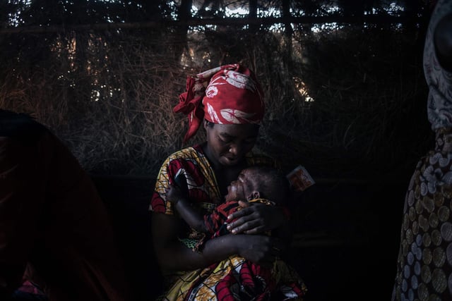 A displaced woman cares for her child who suffers from acute diarrhoea in the makeshift health center of the internally displaced persons camp of Bijombo.