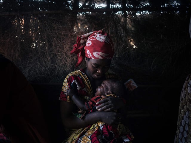 A displaced woman cares for her child who suffers from acute diarrhoea in the makeshift health center of the internally displaced persons camp of Bijombo.