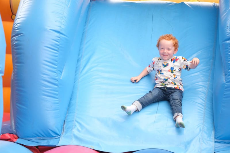 A child having fun with the inflatable slide as people enjoying the Saturday afternoon vibes.