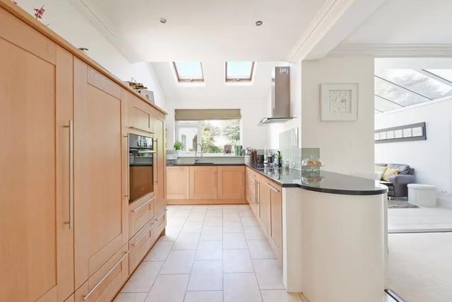 The kitchen has a range of Shaker style fitted units with granite worktops, glass splash-back tiles, and a Kardean Limestone tiled effect floor. Included within the sale is an integrated oven, an induction hob with an extractor above, a dishwasher, fridge, and freezer.