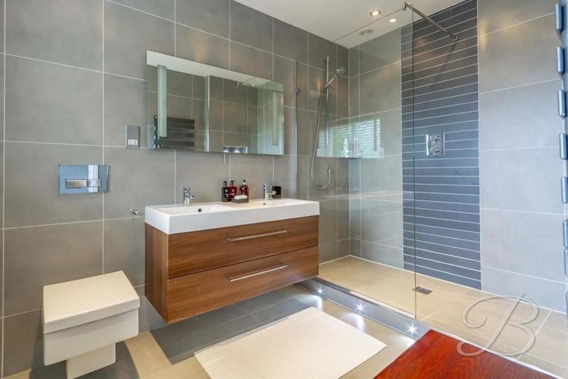 Marvel at this en-suite bathroom with its stylish, walk-in shower. A fully-tiled suite also includes a double vanity unit.