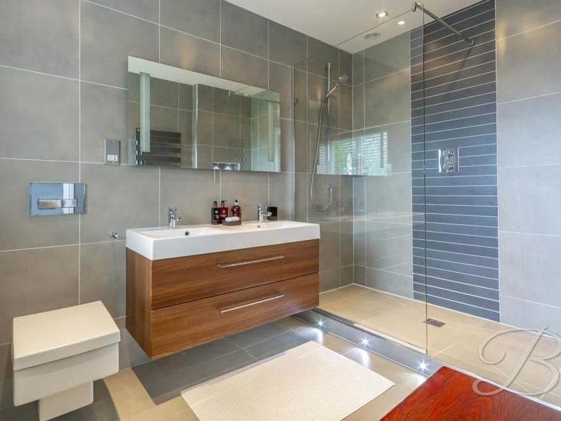 Marvel at this en-suite bathroom with its stylish, walk-in shower. A fully-tiled suite also includes a double vanity unit.