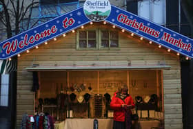 A stall holder knits scarves as she waits for customers at Sheffield's Christmas Market  (Photo by Christopher Furlong/Getty Images)