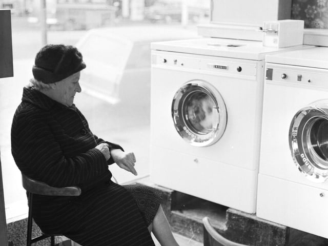 Time moves slow for this woman waiting for her washing to finish spinning.