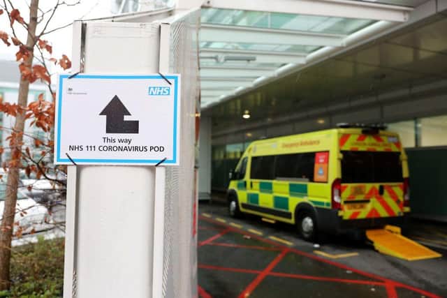 A sign directs patients towards an NHS 111 Coronavirus (COVID-19) Pod, where people who believe they may be suffering from the virus can attend and speak to doctors, is seen outside University College Hospital in London (Photo by ISABEL INFANTES/AFP via Getty Images)