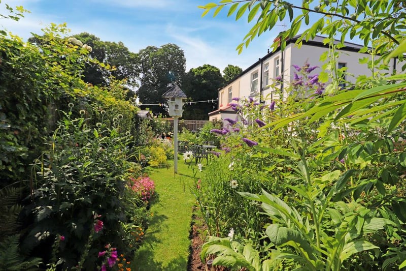 The spacious rear garden has hidden pathways surrounded by wildflowers.