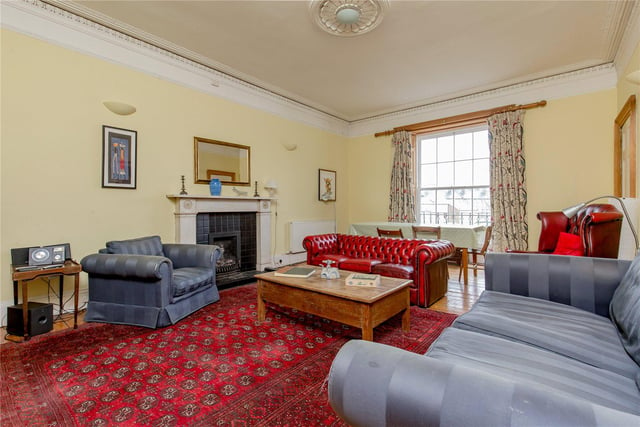 The large living room is situated at the back of the property and has features such as cornicing and a fireplace.