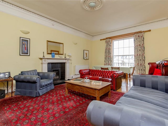 The large living room is situated at the back of the property and has features such as cornicing and a fireplace.
