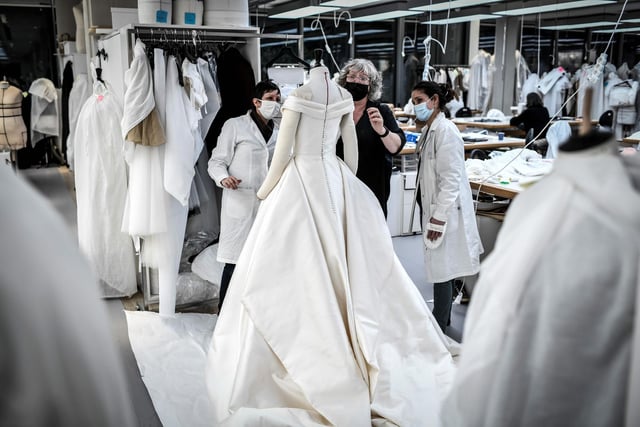Seamstresses work on a dress at Christian Dior's Haute Couture fashion house workshop in Paris