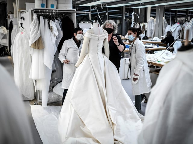 Seamstresses work on a dress at Christian Dior's Haute Couture fashion house workshop in Paris
