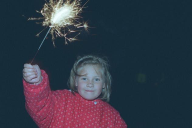 Six year old Lori Johnson with a sparkler at the Rotary Club bonfire in 1996.