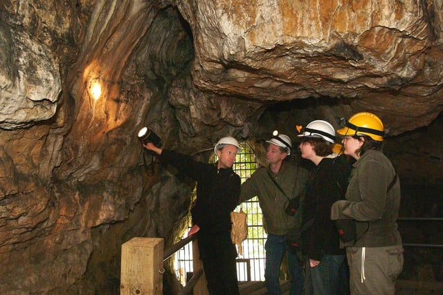 John Charlesworth, Creswell Crags' Principal Heritage Ranger pictured in Robin Hoods Cave with visitors back in 2006