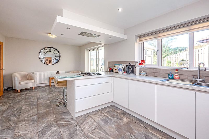 The light and airy kitchen offers wall, floor and utility styled cupboards with complementing work surface.