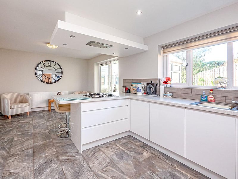 The light and airy kitchen offers wall, floor and utility styled cupboards with complementing work surface.