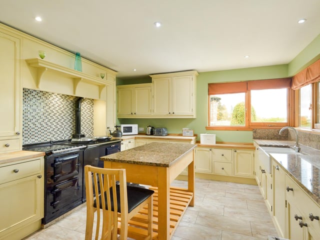 The L-shaped kitchen/family room has a double-oven AGA, granite worktops and a dining area, as well as a wood-burning stove and doors leading to the garden