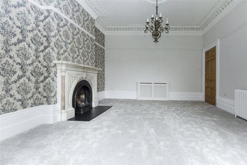 Decorative, fuel-effect ,cast iron gas fire open to the chimney with a decorative marble surround.