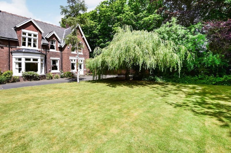 The home is accessed via double electric gates and has a driveway and a large turfed area in the front garden.