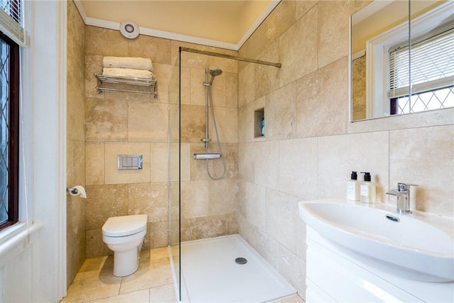 The master en-suite bathroom features a walk-in shower, toilet and sink, heated towel rail, with neutral modern tiling.