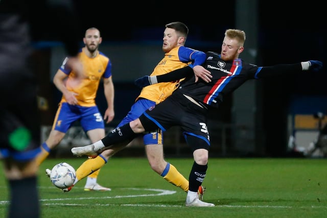 Mansfield Town defender Will Forrester battles for possession.
