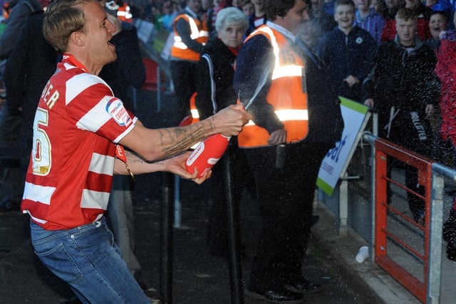 James Coppinger sprays champagne on supporters at the Keepmoat
