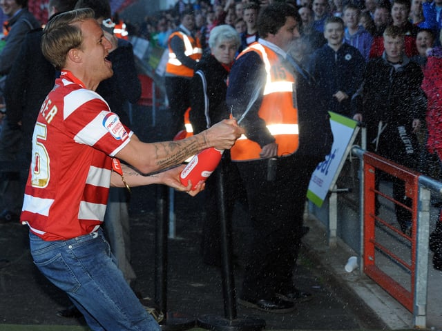 James Coppinger sprays champagne on supporters at the Keepmoat